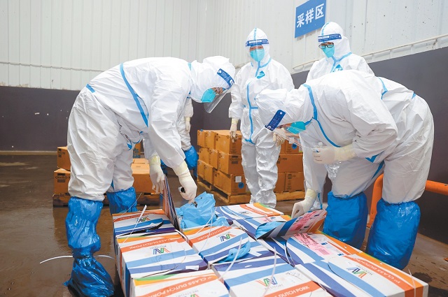 盐田监管仓的工作人员正在对冻品进行采样。.jpg