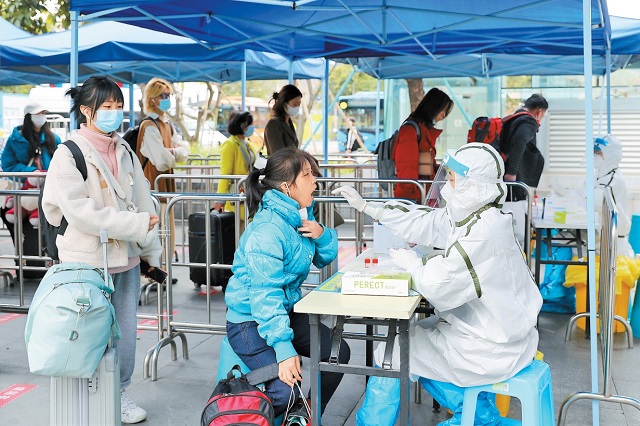 2月8日，在深圳北站西广场，医护人员为返深旅客做核酸采样.jpg