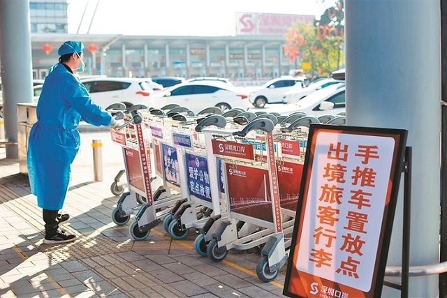 在深圳湾口岸，工作人员在整理行李手推车。 2.jpg