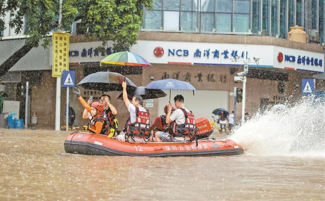 昨日上午，罗湖区嘉宾路与建设路十字路口积水严重，深圳公益救援队通过皮划艇运送市民安全通过内涝点位。.jpg