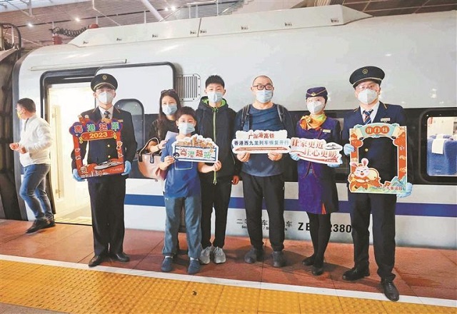 昨日，广深港高铁正式恢复通车，首趟内地开往香港西九龙站的旅客列车于7时24分从深圳北站发出。图为乘客与深圳北站工作人员合影留念。.jpg